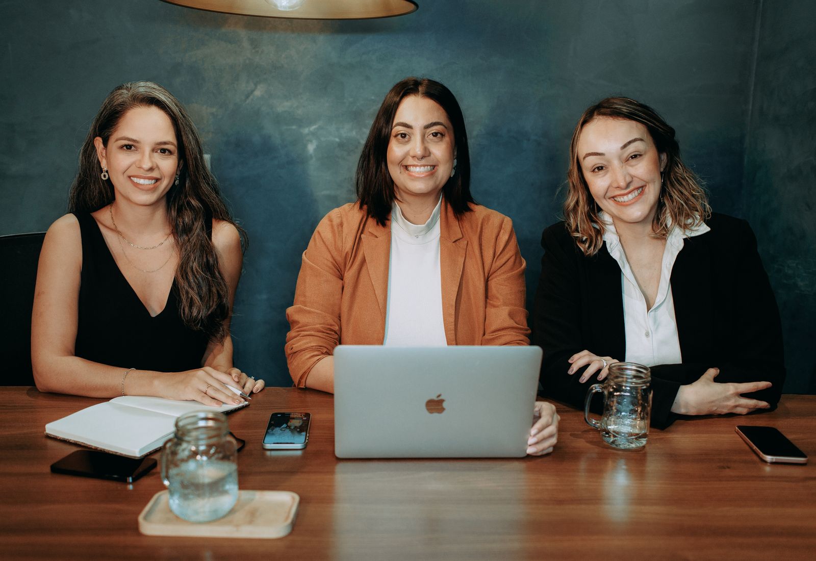 Equipo de trabajo reunido en una mesa de oficina con computadoras portátiles